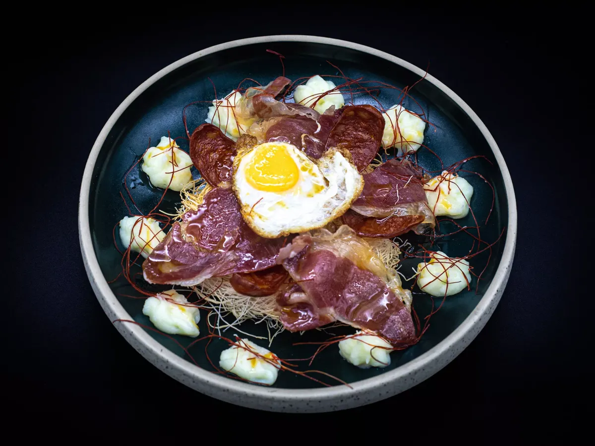 Huevos con chorizo, jamón, y patatas paja